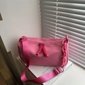 Pink nylon crossbody bag with wide strap and decorative chain in soft indoor lighting - Rose Pink