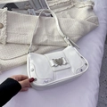 White Y2K underarm bag with silver heart buckle and rivets on cream tweed backdrop - White