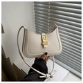 Détail du sac croissant en cuir crème avec fermoir doré et bandoulière à nœuds élégante - Blanc