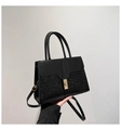 Close-up of black stone textured leather tote with elegant gold metal twist lock buckle - Black