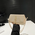 Detail van beige tas met glinsterende strassteentjes, goudkleurig logo en kwastje - Khaki