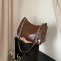 Detail view of deep brown faux leather shoulder bag with a silver chain and sleek zipper - Brown