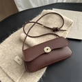 Minimalist chocolate leather underarm bag with golden textured lock and slim shoulder strap - Brown