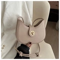 Detail of a beige crescent moon bag featuring a gold clasp and a unique knotted strap - Khaki