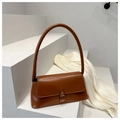 Détail d'un sac baguette en cuir marron avec garniture en bronze sur fond minimaliste - Beige