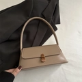 Borsa baguette kaki con chiusura a scatto in bronzo vintage su una giacca nera - Cachi