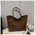 Dettaglio della trama intrecciata della borsa tote marrone scuro con rivetti dorati - Marrone