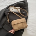 Khaki woven crossbody bag with adjustable strap on a grey blazer, 2025 trendy style - Khaki