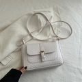 White woven retro baguette shoulder bag with gold buckle on elegant white suit background - White