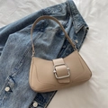 Chic beige crescent underarm bag with silver buckle on a denim and white background - Khaki