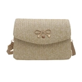 Detail of woven straw handbag featuring V-shape texture and a gold metal bow charm - Khaki