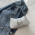 Metallic silver leather baguette bag with square metal buckle on denim jacket background - Silver