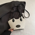 Bolso tipo cubo beige texturizado con asas de cuero negro y correa de bandolera - Negro