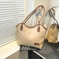 Bolso tote beige y marrón con borde ondulado y logotipo de moda sobre un escritorio - Caqui