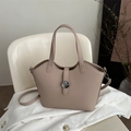 Chic beige bucket bag with metal N buckle on corduroy fabric and white chair background - Khaki