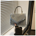 Détail du sac à bandoulière en denim avec bords effilochés et chaîne dorée chic - Bleu