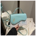 Dettaglio della borsa piano blu menta con stampa tastiera e ricamo chiave di violino oro - Blu