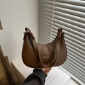 Dark brown leather crescent hobo bag with a silver bow accent and adjustable strap - Brown