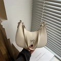 Chic cream dumpling shoulder bag with silver bow accent and minimalist leather texture - White