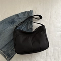 Minimalist black canvas crossbody messenger bag with dual front pockets on denim - Black