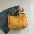 Minimalist bright yellow canvas crossbody bag with adjustable black strap and front pocket - Yellow