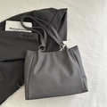 Dark grey tote bag with woven texture and metal ring shoulder strap detail - Black