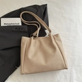 Minimalist beige tote bag with textured canvas and gold ring straps in a lifestyle setting - Khaki