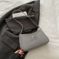 Bolso de hombro plateado con textura tejida y un detalle de lazo metálico - Gris