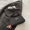 Elegante bolso de hombro negro con acabado brillante y adorno de lazo plateado - Negro