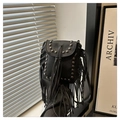 Close-up of black leather crossbody bag featuring vintage fringe and silver rivet details - Black