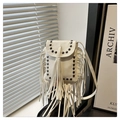 Detail view of beige crossbody bag featuring fringe tassels and black rivet studs - White