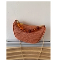 Detailed view of red woven straw handbag featuring amber resin beads and gold chain strap - Brown