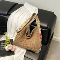 Bohemian braune Stricktasche mit bunten Sonnenblumen-Trägern auf einem Sofa - Khaki