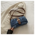 Dettaglio della borsa baguette blu con finiture in pelle marrone e fibbia in metallo dorato - Blu scuro