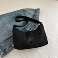 Minimalist black canvas crossbody bag with brand patch and adjustable shoulder strap - Black
