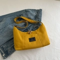 Minimalist yellow nylon crossbody bag with adjustable strap on a denim jacket background - Yellow