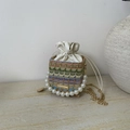 Detail der bunten Stroh-Eimertasche mit Perlengriff und Kordelzugverschluss - Khaki