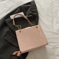 Bolso rosa con patrón de serpiente sobre chaqueta negra y detalle de cadena dorada - Rosa