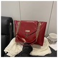 Dettaglio borsa tote in pelle lucida bordeaux con catena dorata e pendente a forma di cervo - Rosso