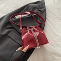 Red patent leather bucket bag with pearl chain detail and drawstring closure - Red