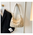Gesteppte beige Puffer-Tasche mit Reißverschlussfach vorne an einer Holztür hängend - Khaki