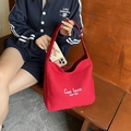 Red canvas tote bag with white lettering and wide shoulder strap for casual commute - Red