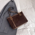 Brown corduroy tote bag with leather straps on a grey blazer and white fabric background - Brown