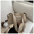 Detailed close-up of a beige baguette bag with a stylish large silver metal buckle on a sofa - Khaki
