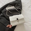 White quilted crossbody bag with V-shaped stitching and metal chain strap on blazer - White