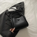 Minimalist black tote bag with dual top handles and long strap on a grey blazer - Black