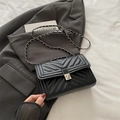 Black quilted flap bag with V-shaped stitching and a silver metal chain strap - Black