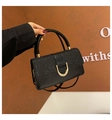 Detail der schwarzen Handtasche mit glitzernder Klappe und goldenem D-Ring-Metallverschluss - Schwarz