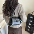Chic black faux leather baguette bag worn by a model in a cozy interior setting - One Size / Black