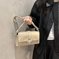 Chic cream leather baguette bag with flap closure worn by a model for a stylish look - One Size / Khaki